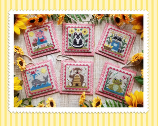 Set of cross-stitched animal designs on fabric with sunflowers in the background