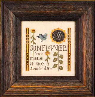Framed cross-stitched design of sunflowers and text on a white background