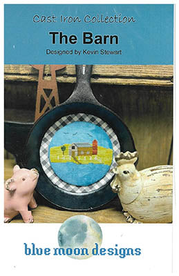 Product packaging for 'The Barn' design by Blue Moon Designs, featuring a cast iron skillet with a checkered pattern and a small barn illustration.