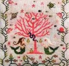Cross-stitched design of mermaids and a coral tree with a pink background