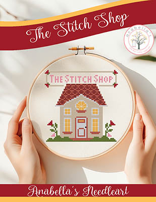 The Stitch Shop cross stitch pattern by Anabella’s featuring a small storefront building with floral accents and the phrase “The Stitch Shop” in a hoop design.