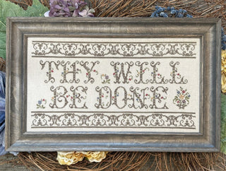 Cross-stitch pattern featuring the phrase “Thy Will Be Done” in an ornate font, surrounded by vintage-style floral motifs in soft browns, pinks, and blues on a cream background with a decorative border.