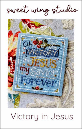 Victory in Jesus cross stitch pattern by Sweet Wing Studio featuring a faith-based sentiment stitched in blue tones with floral accents in a sampler-style layout.