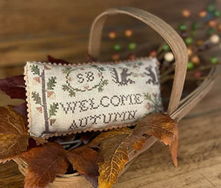 Welcome Autumn Pillow cross stitch by Mani Di Donna featuring fall colors, squirrels, and a rustic sampler-style greeting finished as a small pillow
