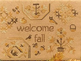 Fall-themed Quaker-style cross stitch design with the words “Welcome Fall,” surrounded by autumn leaves, birds, acorns, pumpkin, and owl on tan background.
