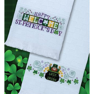 Two embroidered towels with St. Patrick's Day designs on a green background with shamrocks.