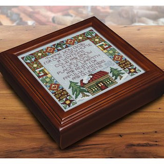 Decorative wooden box with cross-stitched design on a wooden surface