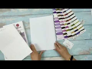Color swatch book and paper samples on a wooden surface